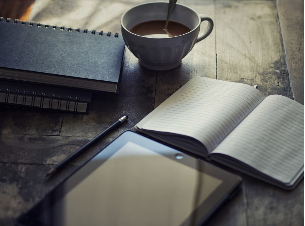 Table avec tablette, carnet et tasse de café